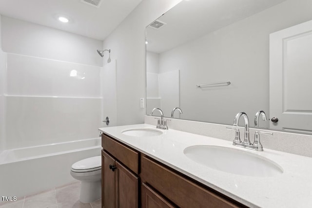 bathroom featuring toilet, visible vents,  shower combination, and a sink