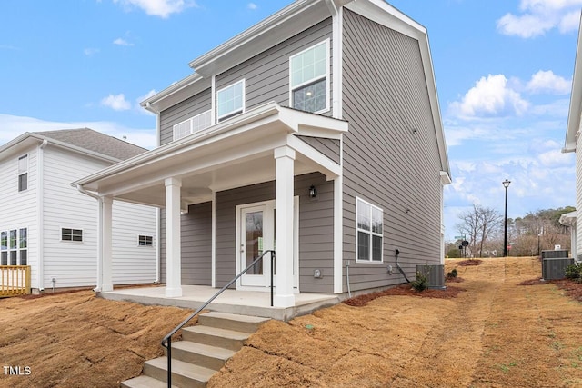 view of front facade with covered porch and central AC