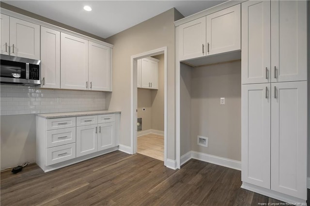 kitchen featuring backsplash, white cabinetry, light stone countertops, and dark wood-type flooring