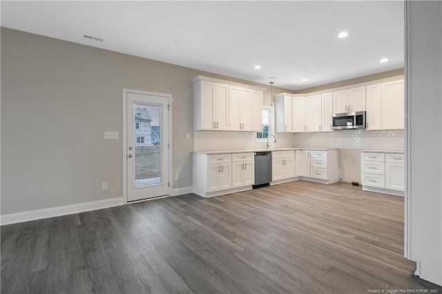 kitchen featuring white cabinets, appliances with stainless steel finishes, and a healthy amount of sunlight