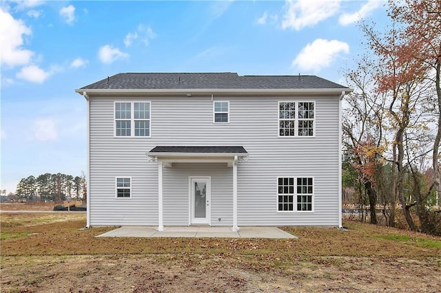 back of property with a lawn and a patio