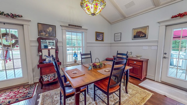 dining space with lofted ceiling, hardwood / wood-style floors, and an inviting chandelier