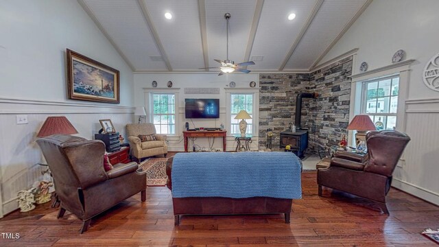 living room featuring a wood stove, plenty of natural light, ceiling fan, and dark hardwood / wood-style floors