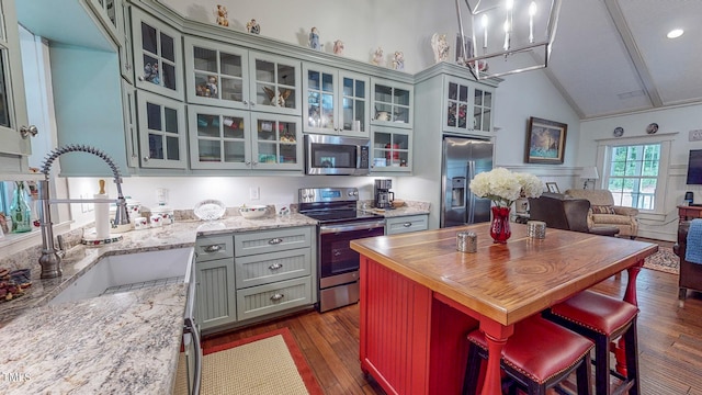 kitchen featuring dark wood-type flooring, a kitchen island, appliances with stainless steel finishes, sink, and high vaulted ceiling