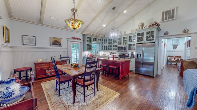 dining space with dark hardwood / wood-style flooring, high vaulted ceiling, and a chandelier