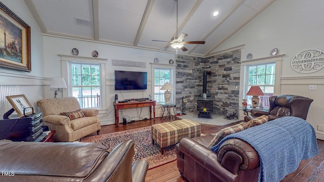 living room featuring a wood stove, hardwood / wood-style floors, high vaulted ceiling, and ceiling fan