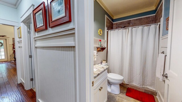 bathroom with wood-type flooring, toilet, vanity, and ornamental molding