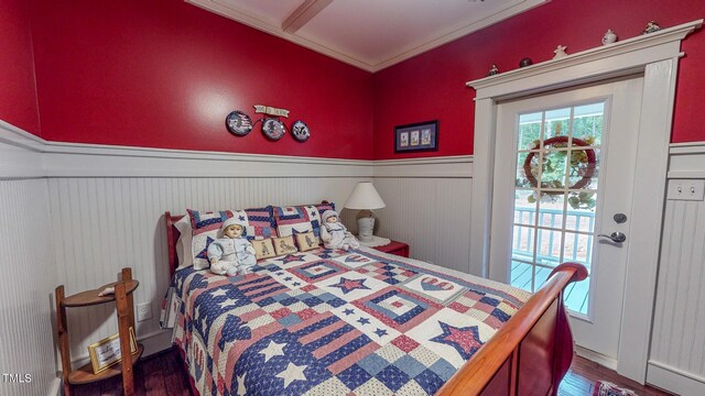 bedroom with dark wood-type flooring, crown molding, and access to exterior