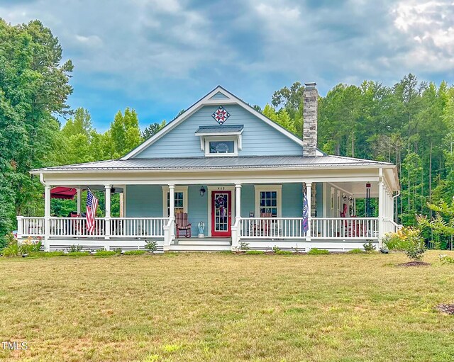 farmhouse inspired home with a porch and a front lawn