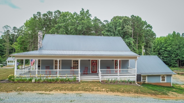 farmhouse-style home featuring covered porch and a front lawn