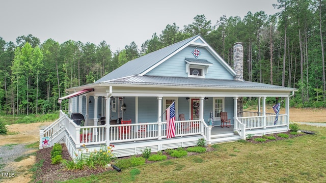 country-style home featuring a porch and a front yard