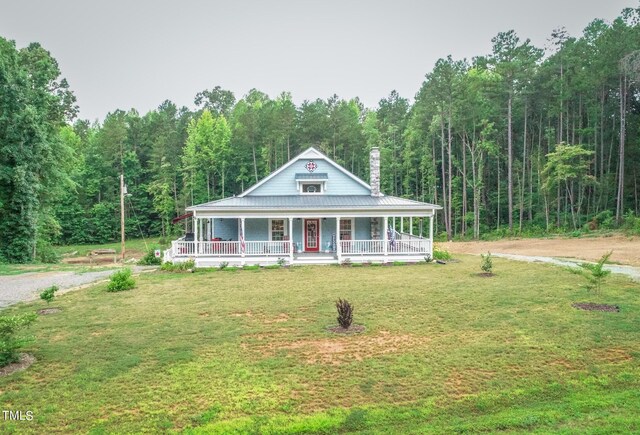 farmhouse-style home featuring a porch and a front yard