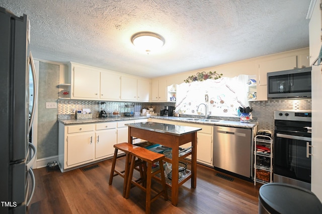 kitchen with stainless steel appliances, dark hardwood / wood-style flooring, sink, and backsplash