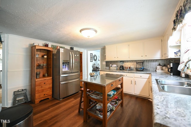 kitchen with white cabinetry, sink, stainless steel fridge, dark hardwood / wood-style flooring, and a textured ceiling