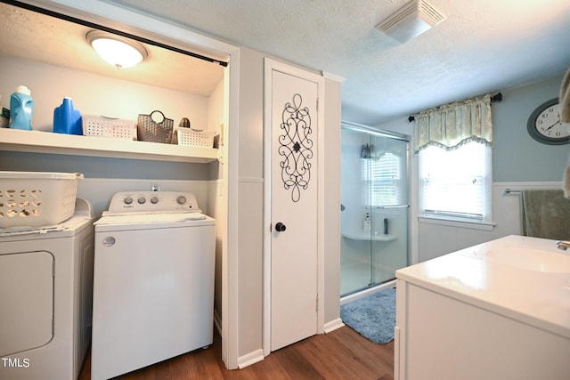 laundry room featuring dark hardwood / wood-style flooring, sink, washer and dryer, and a textured ceiling