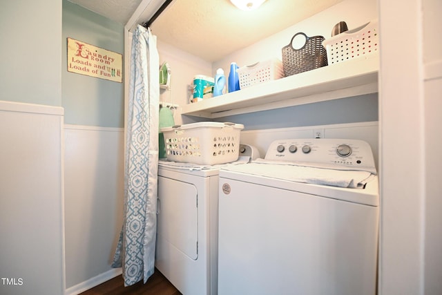 clothes washing area with dark wood-type flooring and washer and clothes dryer