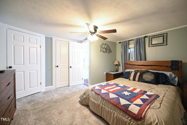 bedroom with ceiling fan, carpet floors, a closet, and a textured ceiling