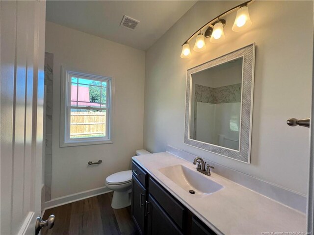 bathroom with vanity, toilet, a shower, and hardwood / wood-style flooring