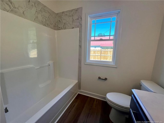 bathroom with toilet, vanity, baseboards, and wood finished floors