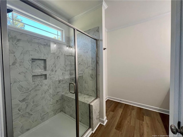 bathroom with a shower with door, crown molding, and hardwood / wood-style flooring