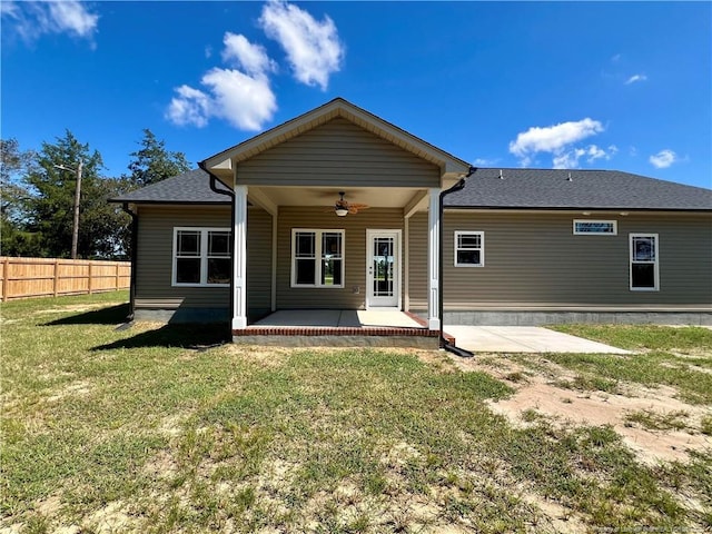 back of property featuring a patio area, fence, a lawn, and ceiling fan