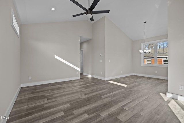 unfurnished living room with high vaulted ceiling, dark hardwood / wood-style flooring, and ceiling fan with notable chandelier