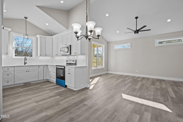 kitchen featuring sink, white cabinetry, tasteful backsplash, light wood-type flooring, and stainless steel appliances