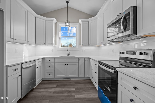 kitchen featuring lofted ceiling, sink, white cabinetry, pendant lighting, and stainless steel appliances