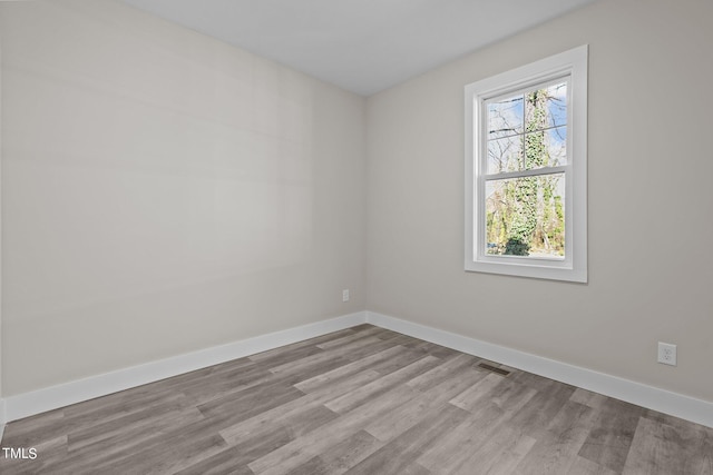 spare room with a healthy amount of sunlight and light hardwood / wood-style floors