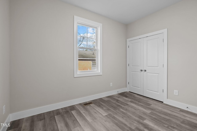 unfurnished bedroom featuring light hardwood / wood-style floors and a closet