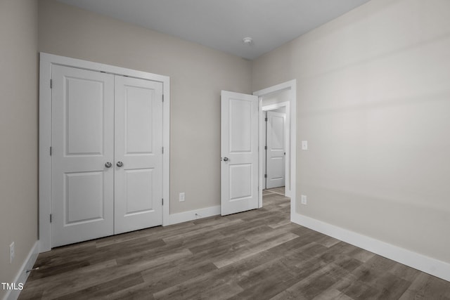 unfurnished bedroom with wood-type flooring and a closet