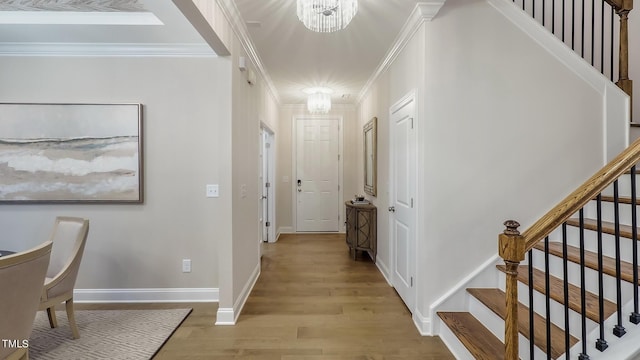 hallway featuring a notable chandelier, light wood-type flooring, and crown molding