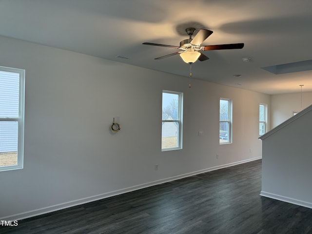 unfurnished room featuring ceiling fan, visible vents, baseboards, and dark wood finished floors