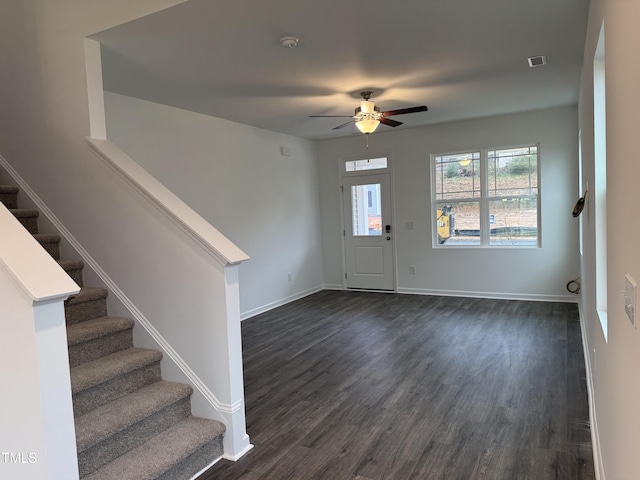 entrance foyer with dark wood-style flooring, visible vents, stairway, and baseboards