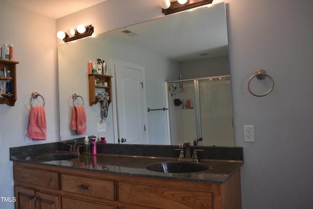 bathroom with vanity and a shower with shower door