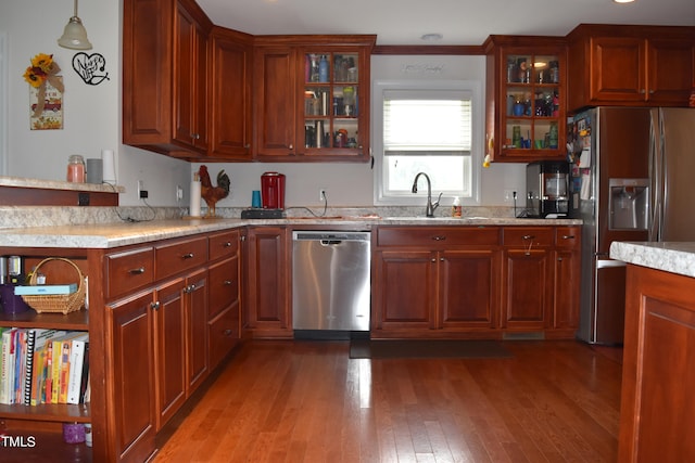 kitchen featuring pendant lighting, light wood-type flooring, sink, and appliances with stainless steel finishes