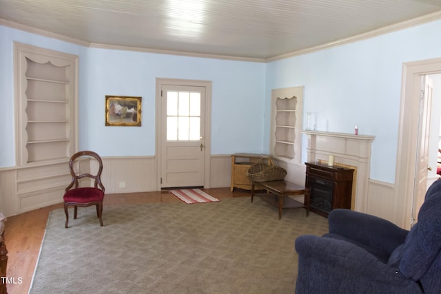 9358 Main St, Castalia, NC 27816 - sitting room featuring wood finished floors, wainscoting, built in shelves, a fireplace, and crown molding