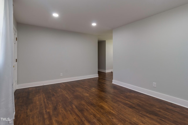 unfurnished room with dark wood-type flooring