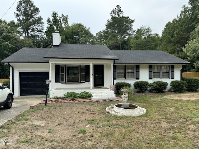 ranch-style home with a garage, a front lawn, and covered porch