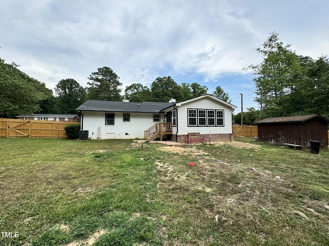 rear view of property with a yard and central air condition unit