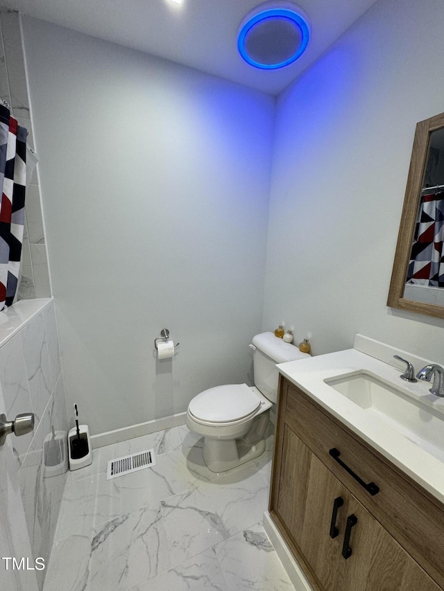 bathroom with tile patterned flooring, toilet, and vanity