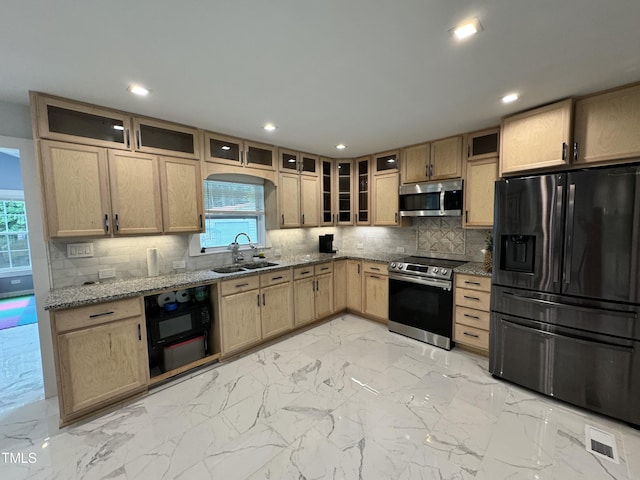 kitchen featuring black appliances, tasteful backsplash, sink, and plenty of natural light