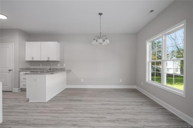 57 E Third St, Parkton, NC 28371 - kitchen with white cabinets, a chandelier, a peninsula, light wood-type flooring, and hanging light fixtures
