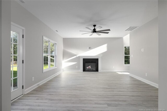 57 E Third St, Parkton, NC 28371 - unfurnished living room featuring wood finished floors, ceiling fan, and a fireplace