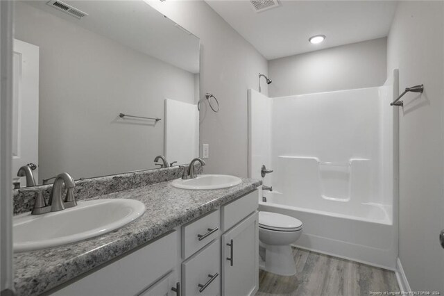 57 E Third St, Parkton, NC 28371 - bathroom featuring wood finished floors, double vanity, and bathing tub / shower combination