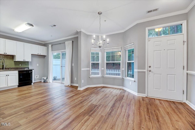 foyer featuring light wood-type flooring, a healthy amount of sunlight, and crown molding