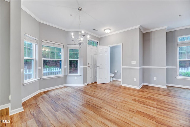 interior space featuring light wood-type flooring, an inviting chandelier, and crown molding