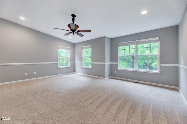 carpeted spare room featuring vaulted ceiling and ceiling fan