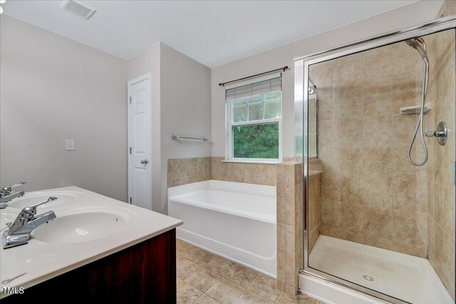 bathroom featuring vanity, plus walk in shower, and tile patterned flooring