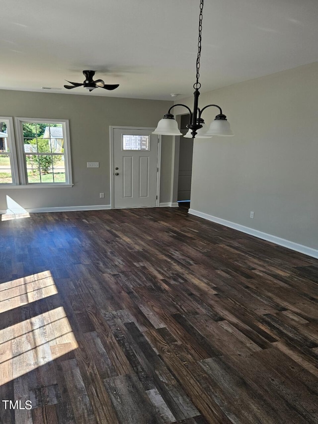 unfurnished living room featuring ceiling fan with notable chandelier and dark hardwood / wood-style flooring